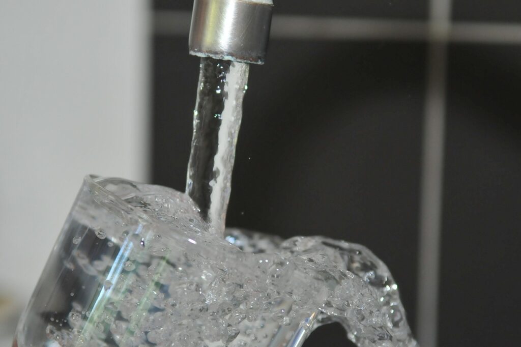 蛇口から出ている水がコップに注がれている