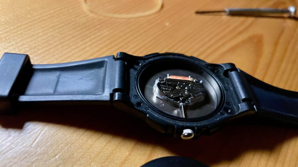 輪ゴムを使用して精密ドライバーで裏蓋を外した腕時計